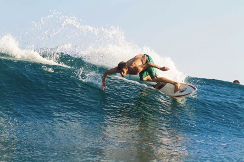 Cody surfing, mid bottom-turn on a clean unbroken wave.
